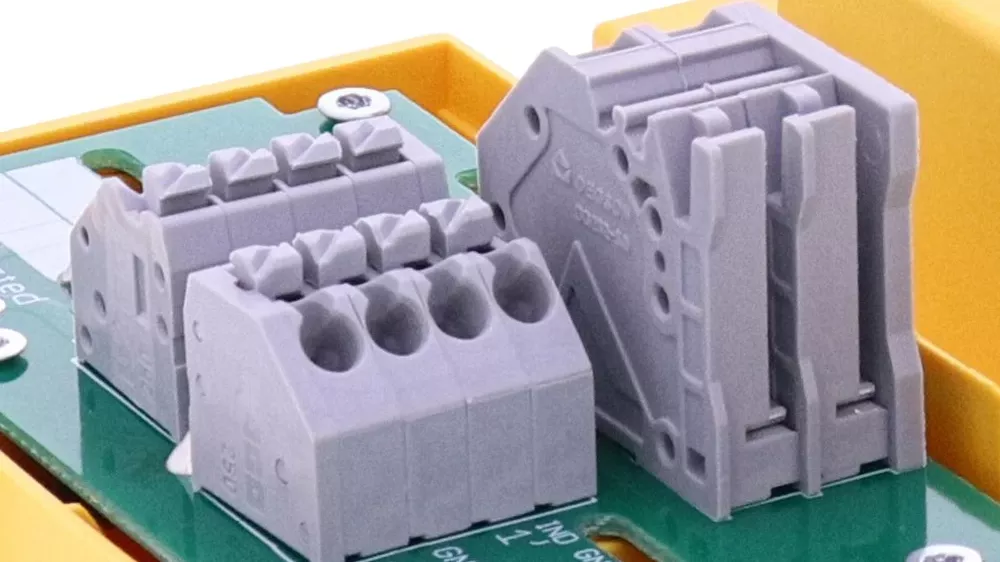 Close-up of terminal blocks and connectors mounted on a green circuit board inside a DEHNbox.